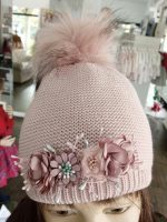 Cappello bimba Bettina Cappello in maglia rasata con dettagli lurex, foderato in pile - 100% cotone, pompon in ecopelliccia e decoro fiori.
