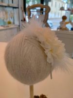 Cerchietto con due fiori e piuma Siena Raffinato cerchietto per bambina con due fiori in tinta unita e piuma. L'accessorio di stile per look eleganti o sporty chic.
