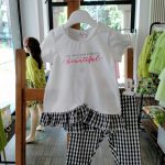 Completo due pezzi La Vie En Rose Completo due pezzi in cotone composto da: T.shirt stampata con maniche corte e balza sovrapposta al fondo in tessuto vichy bianco/nero + Leggings con cintura elastica, stampa vichy bianco/nero all over o tinta unita.