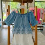 Completo due pezzi La Vie En Rose Completo due pezzi composto da: Top con ampio scollo tondo elasticizzato, spalline sottili regolabili, manichine con fondo a volant, corpino con balza al fondo e ricamo inglese + Shorts in tessuto con elastico dietro, motivo a pannello con decoro bottoni.