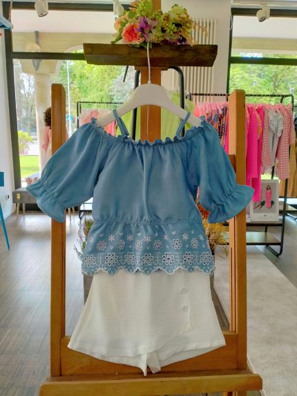 Completo due pezzi La Vie En Rose Completo due pezzi composto da: Top con ampio scollo tondo elasticizzato, spalline sottili regolabili, manichine con fondo a volant, corpino con balza al fondo e ricamo inglese + Shorts in tessuto con elastico dietro, motivo a pannello con decoro bottoni.