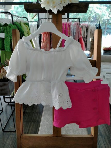 Completo due pezzi La Vie En Rose Completo due pezzi composto da: Top con ampio scollo tondo elasticizzato, spalline sottili regolabili, manichine con fondo a volant, corpino con balza al fondo e ricamo inglese + Shorts in tessuto con elastico dietro, motivo a pannello con decoro bottoni.
