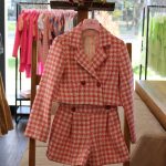 Completo giacca/shorts Completo due pezzi composto da giacca corta con allacciatura a due bottoni, fantasia a quadri rosa + shorts con cintura elasticizzata.