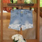 Shorts bimba Shorts in denim modello cinque tasche, vita regolabile con elastico interno, allacciatura a bottone, decoro macramè applicato e fondo sfrangiato.