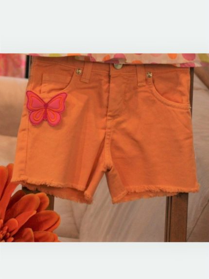 Shorts bimba Shorts in cotone elasticizzato con cintura elastica regolabile, allacciatura con bottone, decoro con patch e fiocco in tulle applicati, fondo sfrangiato.
