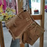 Shorts ragazza Shorts in denim elasticizzato con strappi, modello cinque tasche, color cacao.