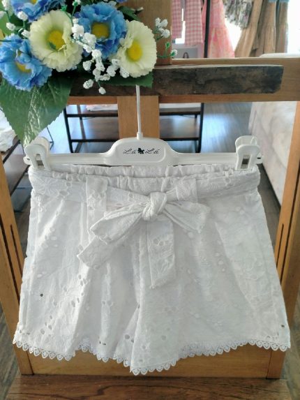 Shorts sangallo ragazza Shorts in sangallo - 100% cotone - con vita elasticata sul retro, cintura in tessuto con passanti, fodera in cotone, decoro merletto al fondo.