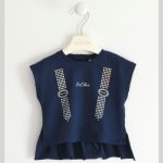 T.shirt bimba m/corta T.shirt stampata Sarabanda per bambina in jersey stretch di cotone. Il modello è particolare con la parte davanti più corta, e la parte dietro con balza arricciata sul fondo. Apertura dietro con bottoni fino alla taglia 3 anni.