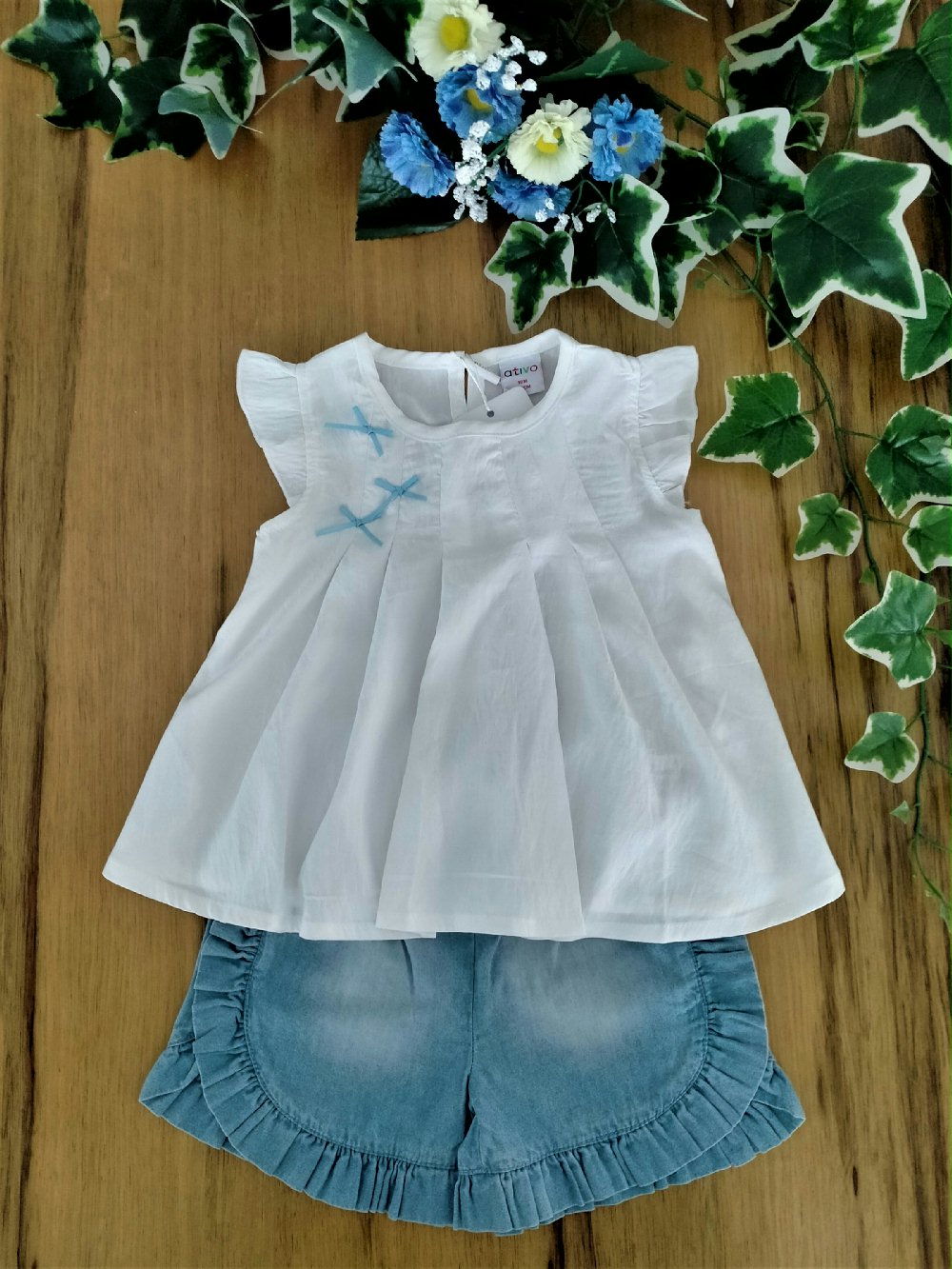 T.shirt m/c Silence Ativo Kids ND7484 00 T.shirt m/c Silence Ativo Kids T.shirt girocollo con manichina ad aletta, modello svasato con fiocchetti applicati sul corpino e pinces a formare delle pieghe larghe, apertura posteriore con comodi bottoncini,
