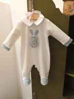 Tutina neonato Coniglietto Tutina con piedini per neonato realizzata in ciniglia con applicazione frontale di un morbido coniglietto, colletto profilato e polsi di colore azzurro polvere a contrasto, apertura dietro e all'interno gamba con bottoncini a pressione. Made in Italy Lista Nascita Corredino